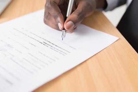 Picture of a man signing a document