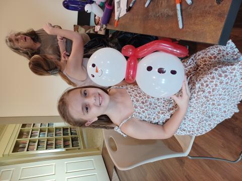 Girl holding balloon snowman